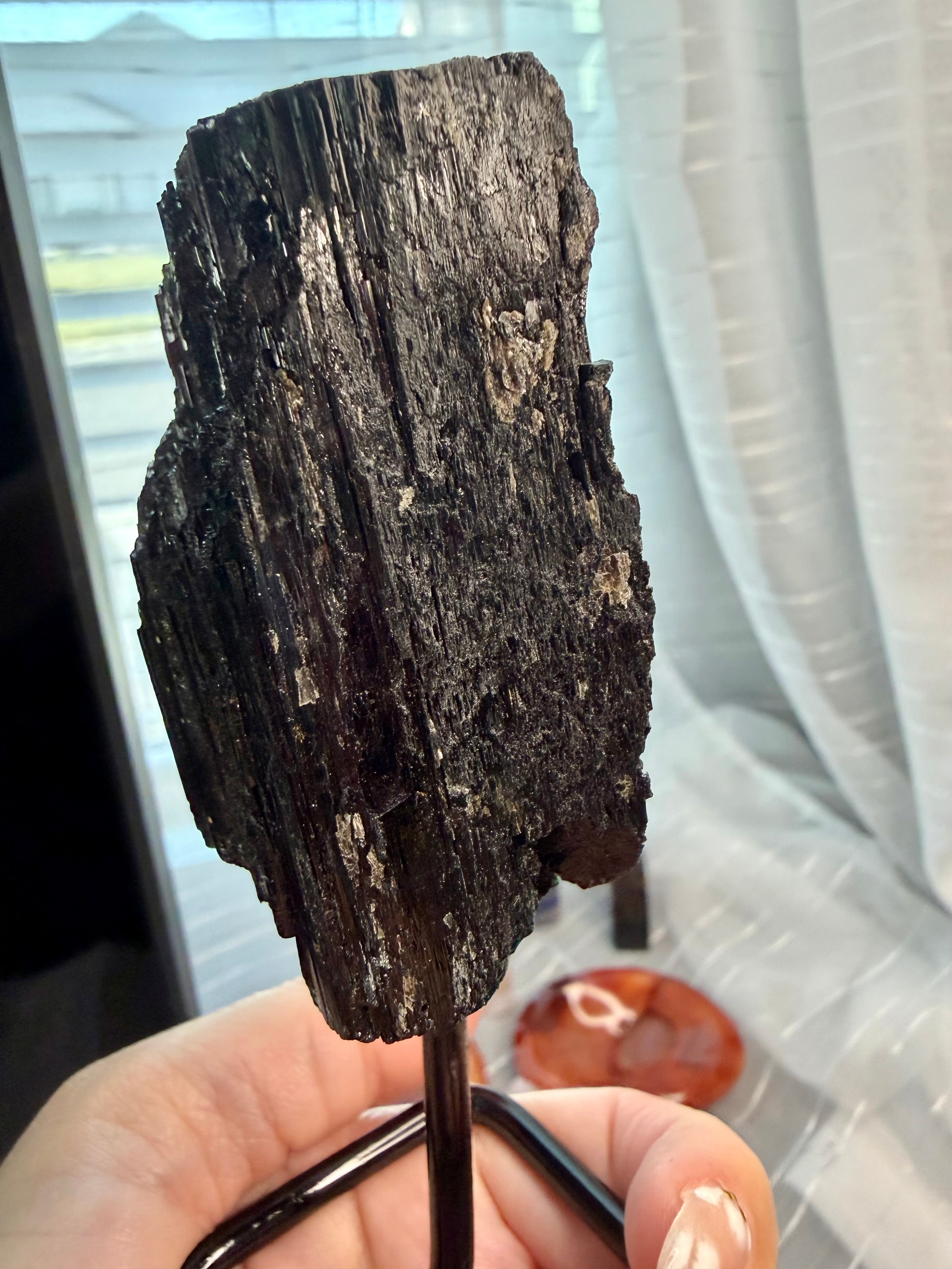 Black Natural Tourmaline mineral specimen mounted on fixed metal display pin.
