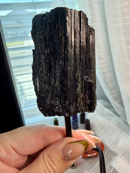 Black Natural Tourmaline mineral specimen mounted on fixed metal display pin.